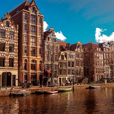Vista de um canal com edificios holandeses ao fundo.